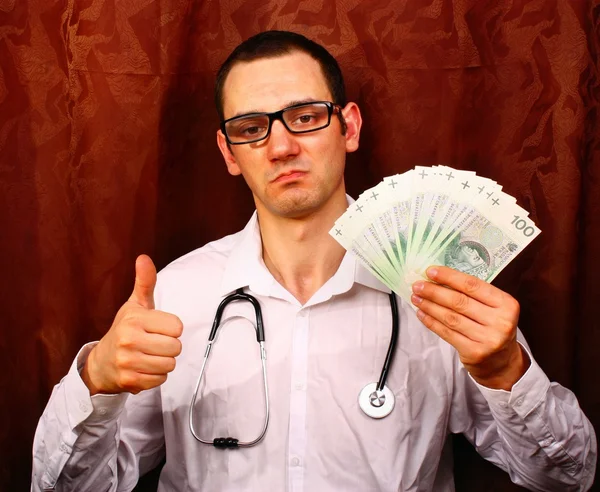 Mies lääketieteen lääkäri pitää Puolan rahaa ja näyttää OK — kuvapankkivalokuva