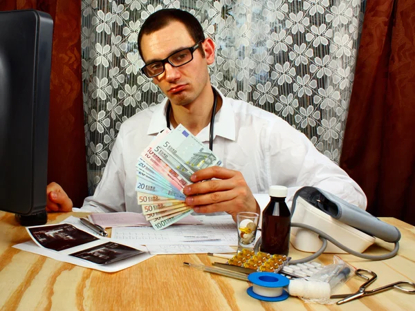 Een knappe dokter met geld — Stockfoto