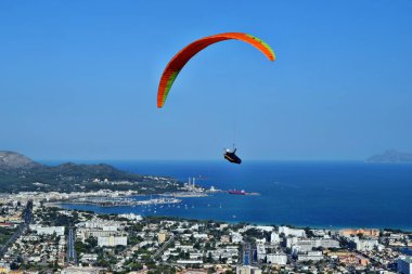 Puig de Sant Marti, Mallorca, İspanya - 27 Ağustos 2018: Port D 'alcudia arka planında Puig de Sant Marti dağının zirvesinden bir adam paraşütle uçuyor