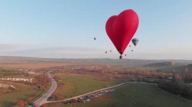 Gökyüzünde bir sürü renkli balon uçuşuyor.