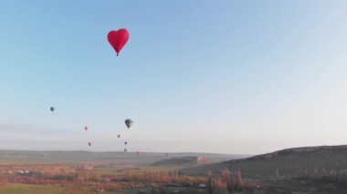Gökyüzünde bir sürü renkli balon uçuşuyor.