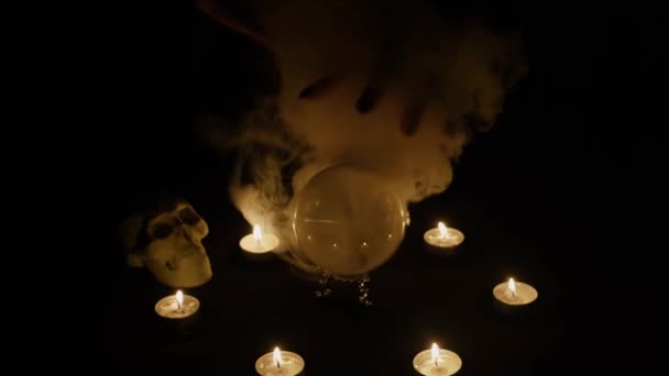 L'indovino che muove le mani sopra la sfera di cristallo magica e le candele intorno, lo scrive sopra, strega che chiama gli spiriti a parlare. — Video Stock