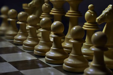 Bir satranç tahtasının yakın çekimi, tüm beyaz taşlarla, oyuna başlamaya hazır.