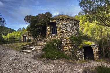 Ormanın ortasında taştan yapılmış bir kulübe.