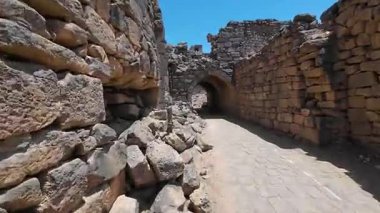 Antik taş kemer yolu güneşli bir avluya çıkıyor. Bosra antik, Suriye