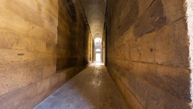 Kemerli tavanı ve sonunda ışık olan antik taş koridor. Bosra antik şehri, Suriye