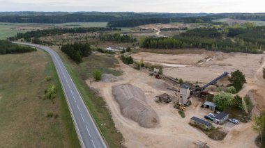 Aerial view of a gravel pit near a road in a rural landscape.