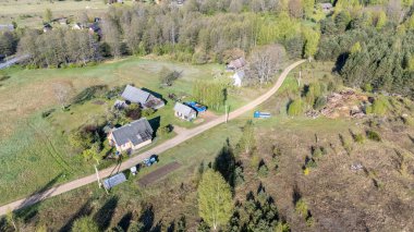 Evleri, toprak yolları ve çevre ormanları olan bir köy havadan görünüyor..