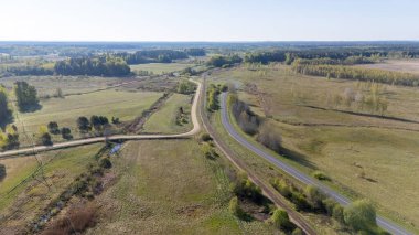 Dolambaçlı yollar ve tarlaları olan kırsal bir arazinin havadan görünüşü.