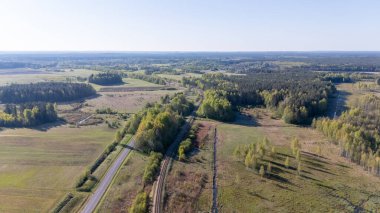 Tarlaları, ormanları ve yolları olan kırsal bir arazinin havadan görünüşü.