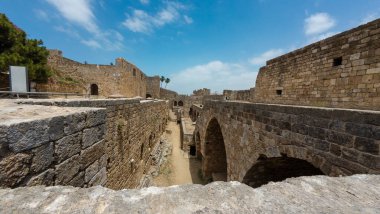 Mavi gökyüzünün altında kemerleri ve yolları olan antik taş kale. Trablus Kalesi, Lübnan.