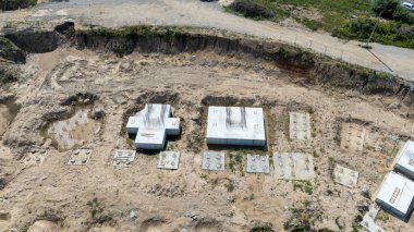 Beton temelleri ve kazılmış toprağı olan bir inşaat alanının havadan görünüşü