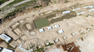 Temelleri ve su havuzları olan bir inşaat alanının havadan görünüşü.