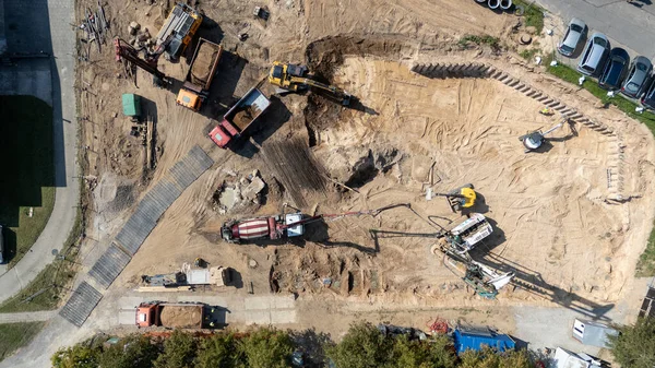 Ağır makineli ve araçlı bir inşaat alanının havadan görüntüsü.