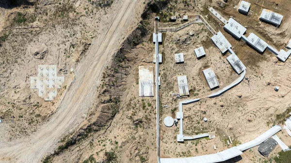 Beton temelleri ve yolları olan bir inşaat alanının havadan görünüşü.