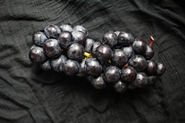 Siyah örtülü bir demet siyah üzüm. Tatlı ve ekşi bir meyve..