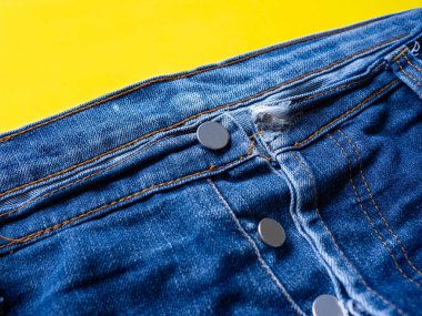 Mavi pantolon kumaşın ince desenini gördü Sarı bir arka plan taktı