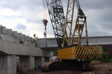 Endonezya 'da önceden gerilmiş köprü inşaatına kirişlerin yerleştirilmesi