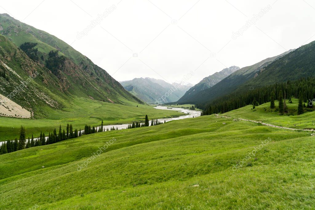 River and mountains with white clouds. Shot in Xinjiang, China.