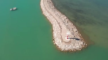 Güneşli bir günde göl ve deniz feneri.