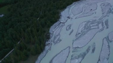 Bulutlu bir günde nehir ve ağaçlar.