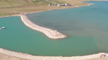 Güneşli bir günde göl ve deniz feneri.