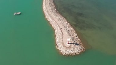 Güneşli bir günde göl ve deniz feneri.