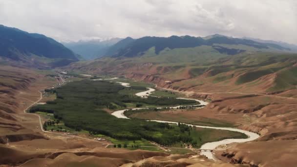 Les sommets montagneux et les prairies sont sous des nuages blancs. — Video