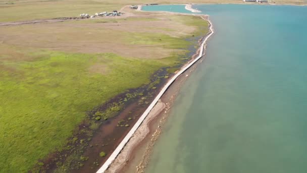 Grassland and blue lake in a sunny day. — Stockvideo