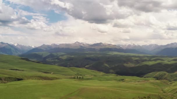 Picos de montaña y pastizales están bajo nubes blancas. — Vídeos de Stock