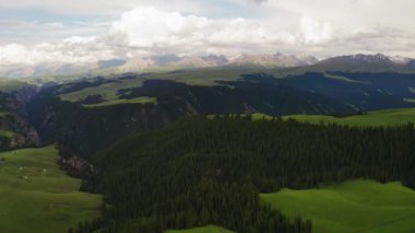 Dağ zirveleri ve çayırlar beyaz bulutların altında. Kalajun otlağında hava fotoğrafı, xinjiang, Çin.