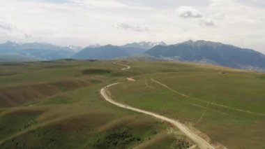Dağ zirveleri ve çayırlar beyaz bulutların altında. Kuokesu vadisindeki hava fotoğrafı, Xinjiang, Çin.