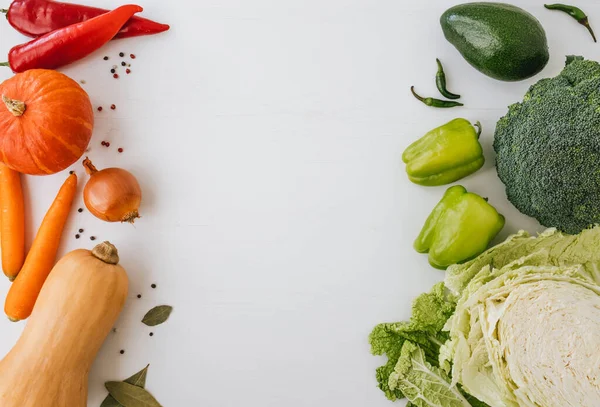 Beyaz arkaplanda taze sebzelerin üst görünümü ve ortasında kopya alanı.
