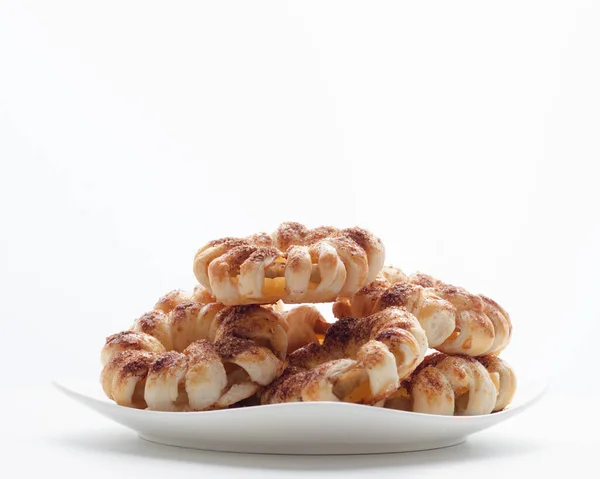 Beyaz arka planda tarçınlı ev yapımı bisküviler. Lezzetli kurabiye konsepti. Görüntüyü kapat.