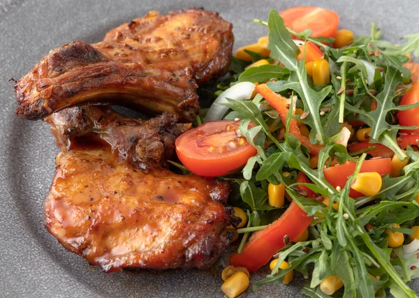 Lezzetli kızarmış domuz pirzolası ve taze sebze salatası. Yemek pişirme konsepti. Yakın görünüm.