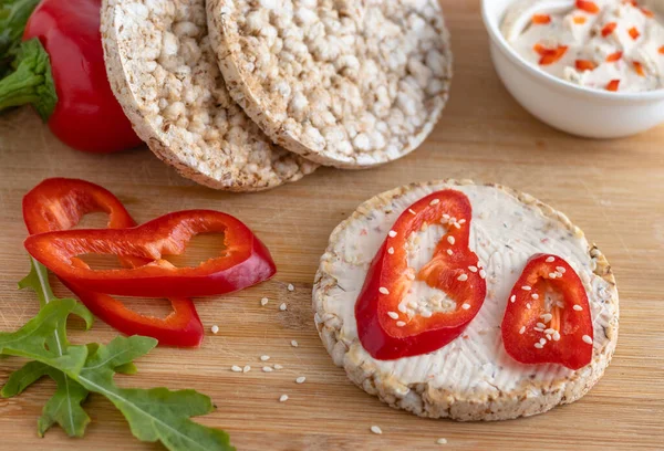 Biber dilimli pirinç krakeri ve ahşap tahtada lezzetli krema. Üst Manzara. Yemek pişirme konsepti.
