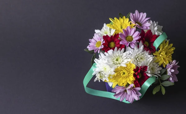 Koyu arkaplanda güzel renkli çiçek buketinin sol tarafında kopya alanı olan üst görünümü.