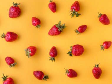 Sarı arka planda taze çilek manzarası. Desenler ve dokular için fikir.