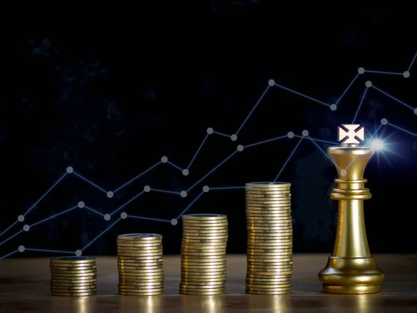 Golden king chess and coins stack with trading graph to successfully with fire spark flare light. Winner of business and successful, leadership strategy concept.