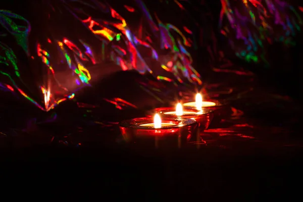 Velas ardiendo en la oscuridad con reflejos de colores — Foto de Stock