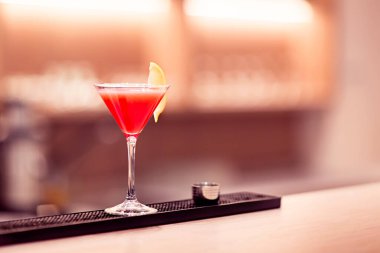 Şarap kadehi, kırmızı içki ve bir dilim limon tezgahın üstünde duruyor..