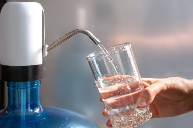 Clean drinking water is poured into the glass with the help of a pump