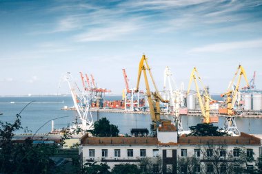 İnşaat vinçleri, vinç yükleyicisi limanda. Fırtınalı deniz, okyanus ve mavi gökyüzü arka planı. Gökyüzünde güzel beyaz bulutlar