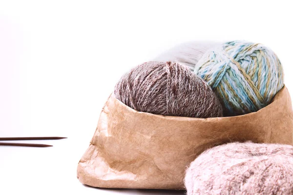 Bolas de fios em cores nuas em um saco de artesanato e agulhas de tricô em um fundo brilhante — Fotografia de Stock