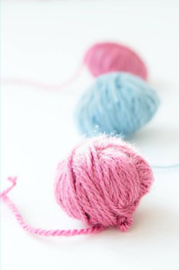 Fotokopi alanı olan açık bir arka planda üç adet çok renkli yün iplik. Kapat.