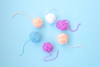 Birkaç renkli iplik izi, açık mavi arkaplan üzerinde fotokopi alanı olan bir daire şeklinde düzenlenmiştir. Kapat.