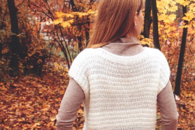 Genç bir kadın sonbahar parkında yürüyor, ormanda. Güzel, parlak bir sonbahar