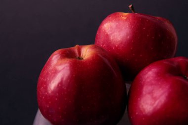 Kırmızı, sulu elmalar siyah arka planda izole edilmiş. Karanlık yemek fotoğrafçılığı. Seçici odaklanma. Yan görünüm