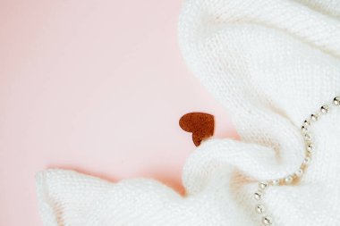 Sevgililer Günü geçmişi. Kırmızı kalp ve pastel pembe arka planda beyaz örgü kumaş. Sevgililer Günü konsepti. Kopyalama alanı olan düz