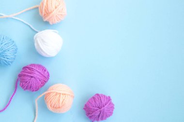 Açık mavi arkaplanda kopyalama alanı olan çeşitli renkli iplikler